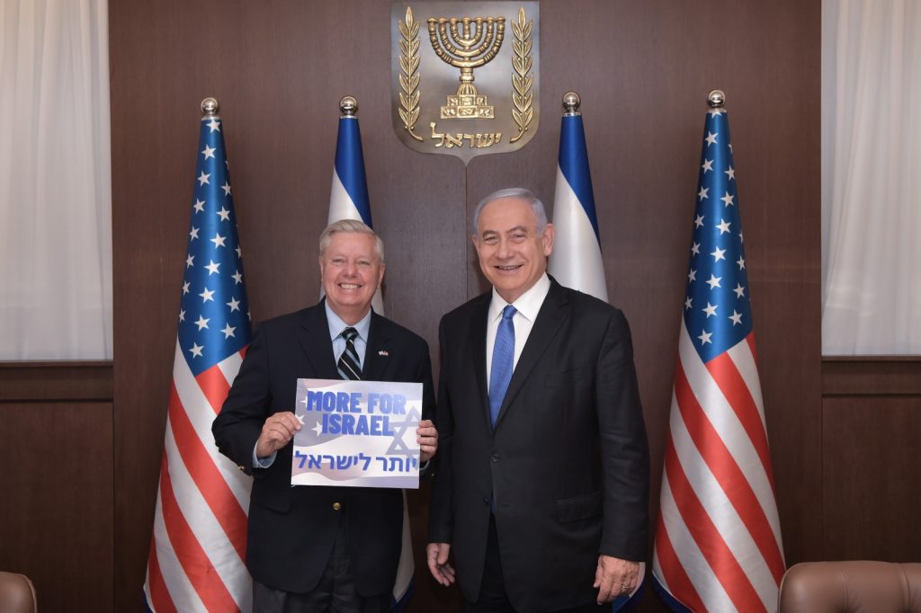 Lindsey “GRIDS” Graham Goes to Israel and Holds Up “More for Israel” Sign