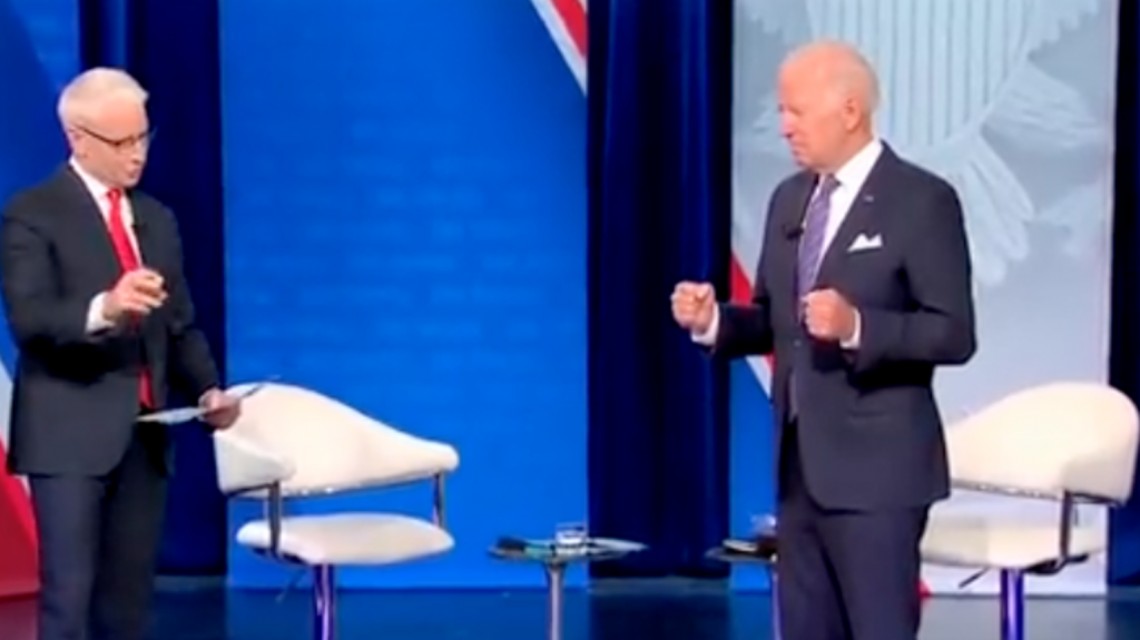 The Biden Holds Out Fists in a Grip While Standing Straight